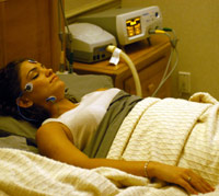 Woman sleeping in a sleep clinic with wires hooked up to her