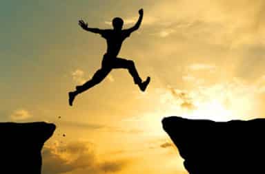 Man jumping across cliffs