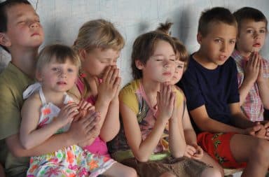 Sad orphan children sitting in an orphanage home