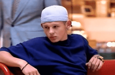 Boy wearing a fitted cap backwards sitting on the sofa