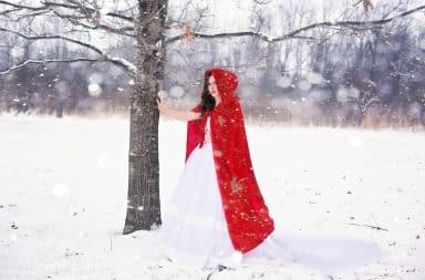 Woman in red robe in the snow outside