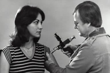 Man giving a vaccine into a woman's arm