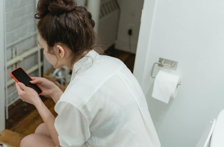 lady on the phone on the toilet